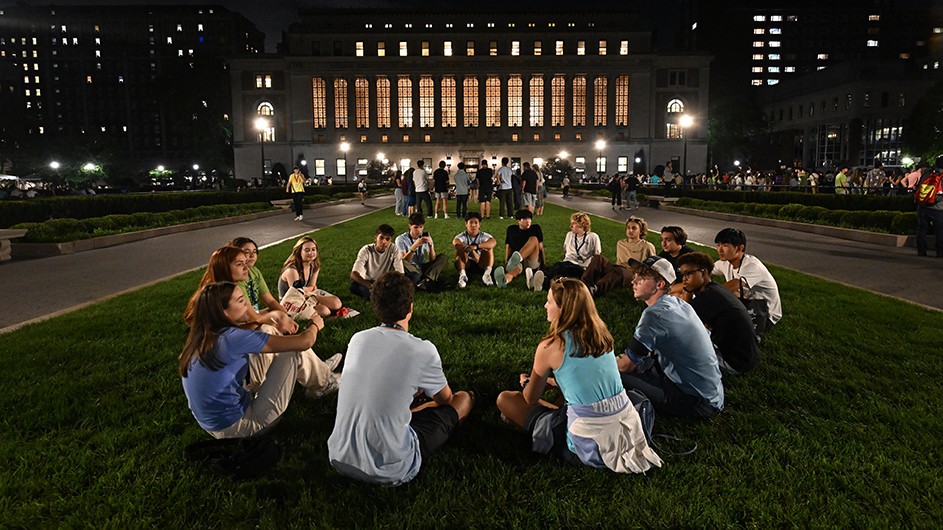 Students meeting in a circle, against the backdrop of Butler Library.