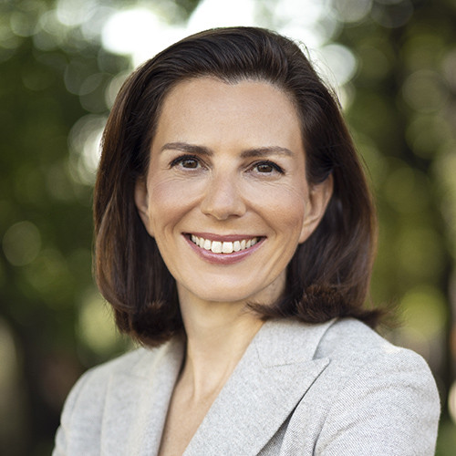 A woman in a light beige top.