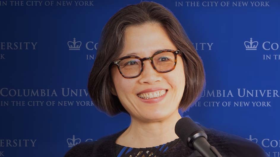 Weiping Wu, a woman with dark, chin-length hair and glasses, against a blue backdrop.