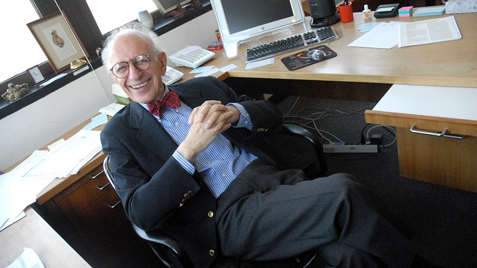 Photo: Chris Taggart. Eric Kandel, a man in a dark suit and bowtie, smiling.
