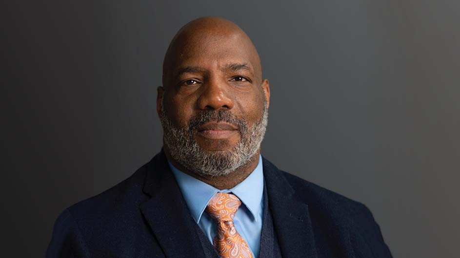 Photo: Calla Kessler. Jelani Cobb, a man in a dark suit and tie.