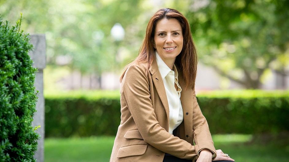 Keren Yarhi-Milo, a woman with long dark hair sitting outside in a tan suit and shirt. 