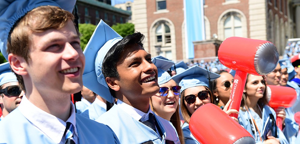 Photo of students celebrating at Commencement with hammer-shaped balloons in their hands.