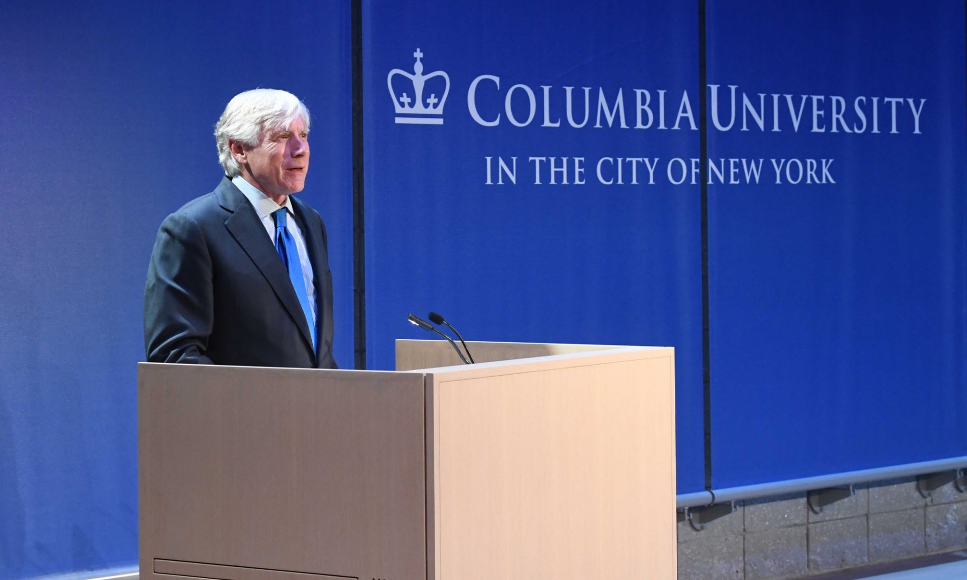 Photo of Lee Bollinger speaking at a podium in the Forum Building auditorium