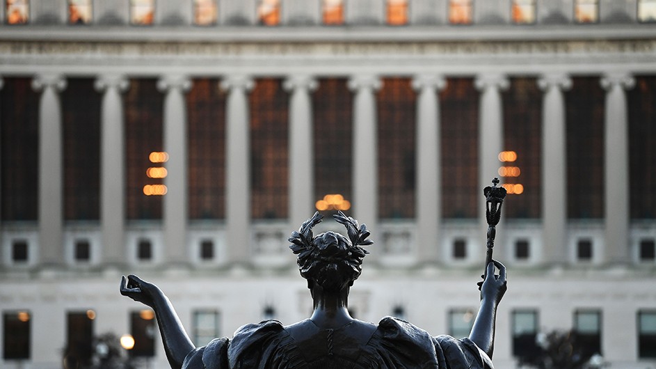 A photo of statue of Alma Mater, from the back, with the columns of Butler Library in the background.