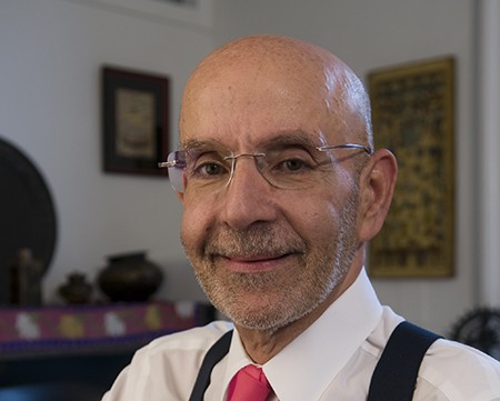 Photo of Peter Awn, a man with glasses in a white shirt and pink tie.
