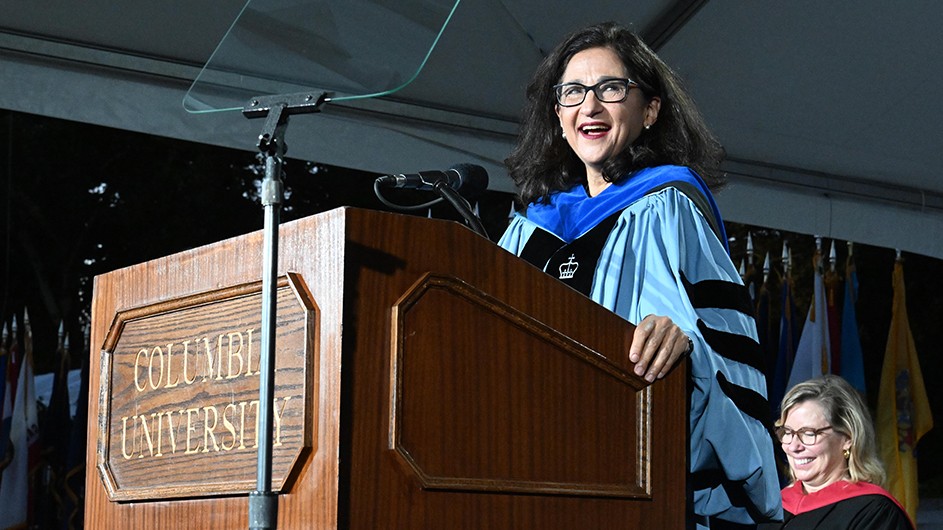 Photo: Eileen Barroso. President Shafik delivers the Convocation address from a podium under a tent in front of Low Library.