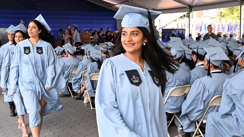 Photo: Eileen Barroso. A group of students process at a graduation ceremony.