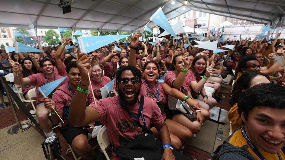 A group of students cheering at Columbia's Convocation during New Student Orientation week. 
