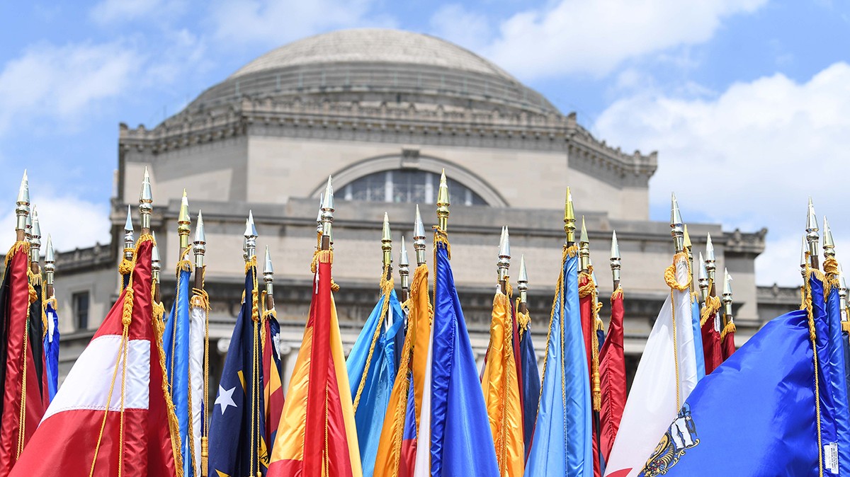 An array of international flags hang in front of Low Library