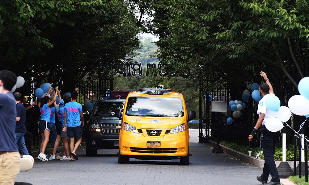 Photo of a taxi arriving on college walk during new student orientation