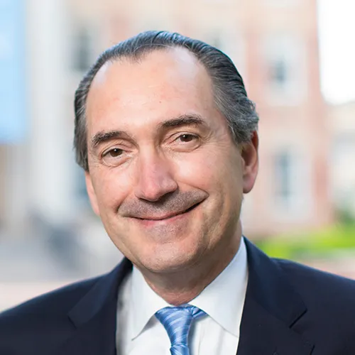 A man in a dark suit and light blue tie. 
