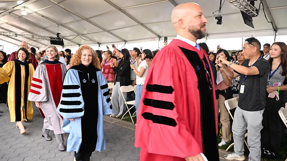 A group of people processing down an aisle in academic robes. 