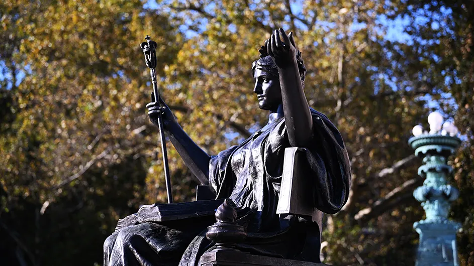 Photo of the statue of Alma Mater, a women in an Ancient Greek robe, with laurels on her head and a scepter in her hand. 