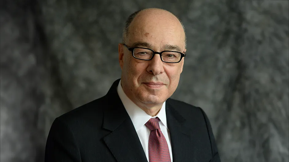 A man with glasses smiling. 