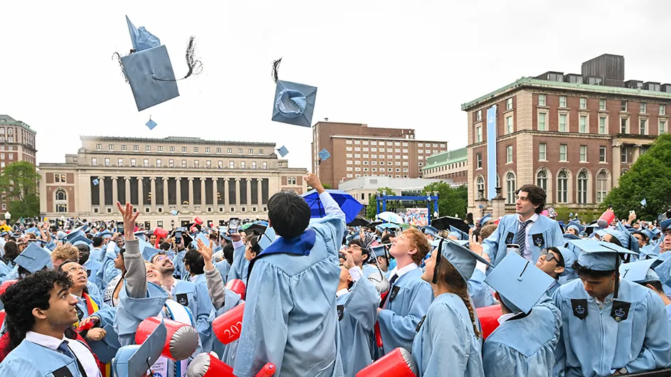 Students throwing their caps in the air at Commencement. 
