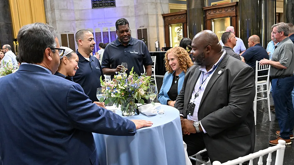 A group of people sitting around a table, talking. 